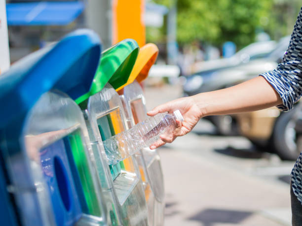 istock Closeup portrait woman hand throwing empty plastic water bottle in recycling bin. 813590964