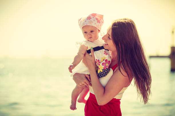 istock Mother playing with baby on beach 813594722