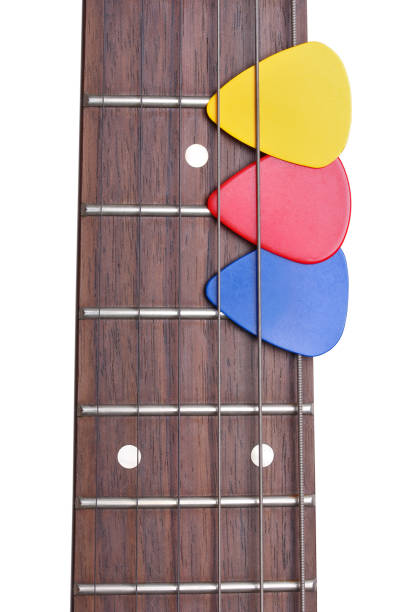 istock Three colored mediators on a guitar fretboard on a white background 813604468