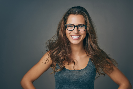 Studio shot of an attractive young woman wearing glasses