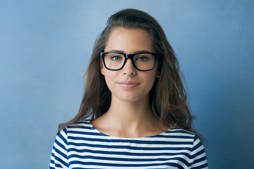 Studio shot of an attractive young woman wearing glasses