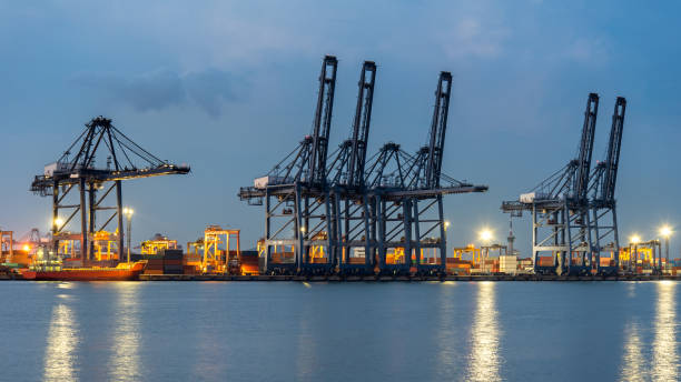 istock Container Cargo freight ship with working crane bridge in shipyard at dusk for Logistic Import Export background.  Industry Concept 813613472