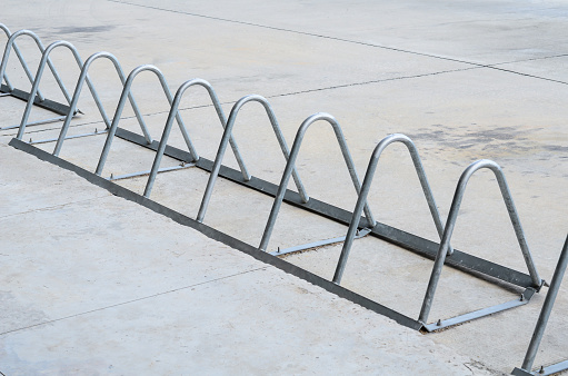 Stainless steel bicycle parking on cement floor.