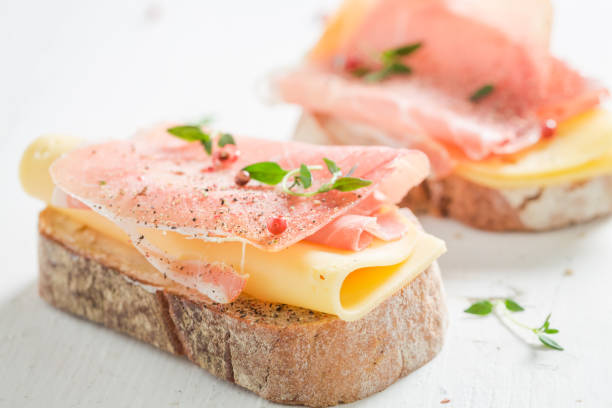 istock Sandwich with ham and cheese for breakfast on white table 813618812