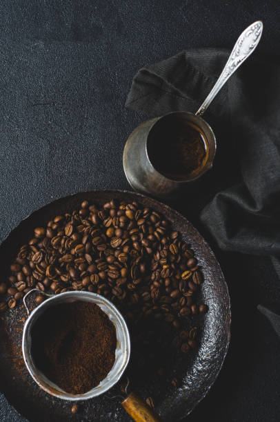 istock Old coffee pot and coffee beans over dark concrete background 813619102