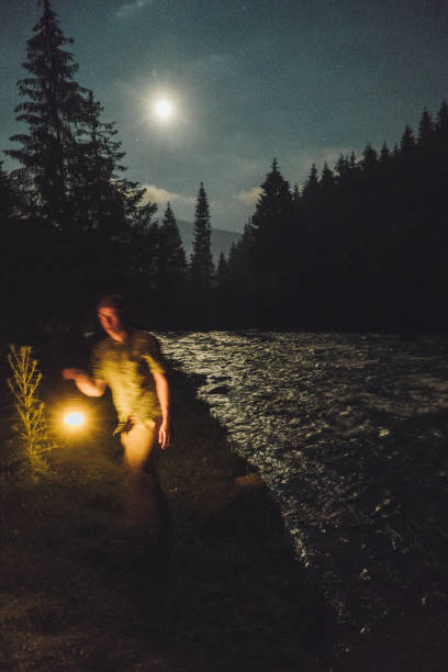 istock Man with gas lantern standing near the river at night 813621668