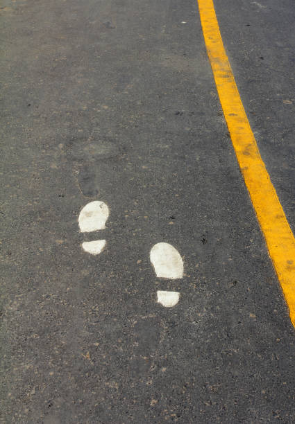 istock Walking Track With Yellow Footprints Painted On Road. 813625024