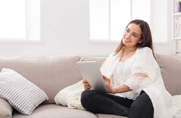 istock Cozy home. Girl in a plaid with a tablet 813628872