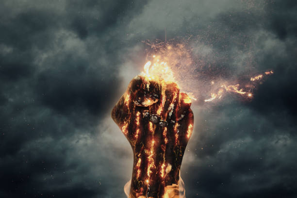 istock fist of fire raising up in front of dramatic grey sky 813628994