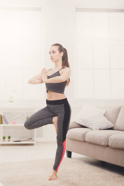 istock Woman yoga stretching at home, tree pose 813629622