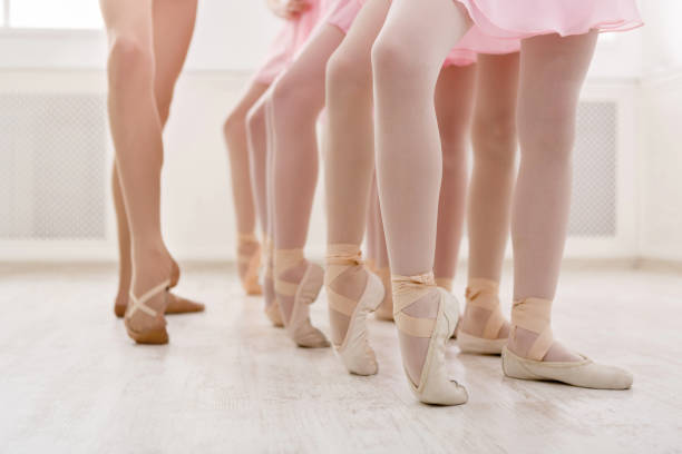 Ballet background, young ballerinas training Ballet background, young ballerinas training. Little dancers legs in pointe shoes, making exercises. Classical dance school, copy space ballet dancer feet stock pictures, royalty-free photos & images