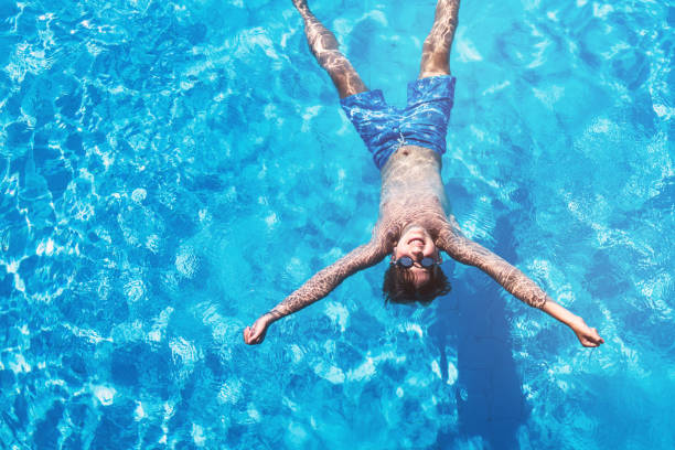 istock Happy boy floating in the swimming pool 813634740