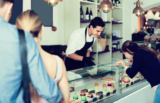 istock Confectioner helping clients to choose sweets 813638288