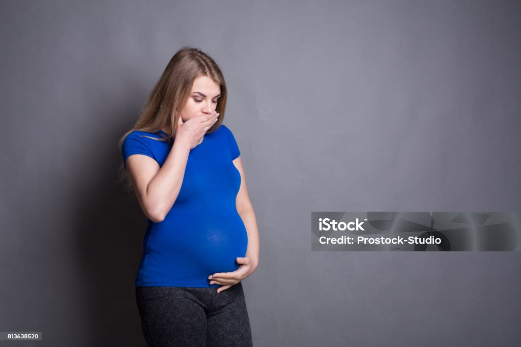 Young vomiting woman portrait Young vomiting woman portrait. Pregnant blonde suffering with nausea. Pregnancy symptoms, gestosis, parenthood concept Abdomen Stock Photo