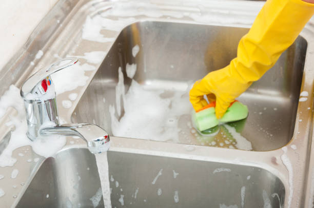 istock Person cleaning the kitchen sink with sponge 813655070