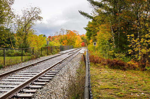Railway Through the Countryside in the Adirondack State Park, NY, on a Rainy Autumn Day. Vibrant Autumn Colours.