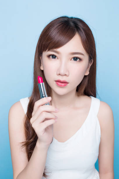 istock beauty woman take lipstick 813665726