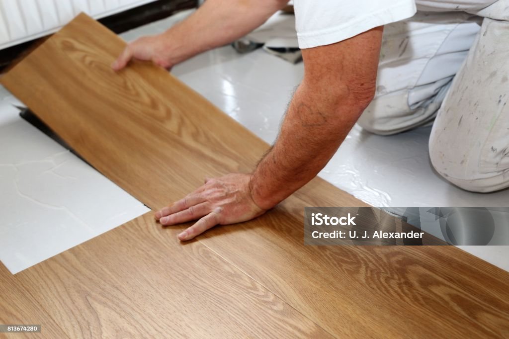 Man laying PVC-floor Man laying professional PVC-floor, close up Flooring Stock Photo