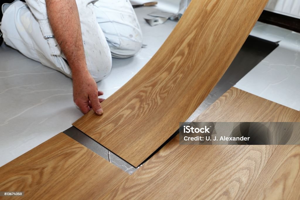 Man laying PVC-floor Man laying professional PVC-floor, close up Flooring Stock Photo