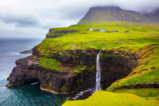 istock Dramatic waterfall on Faroe Islands and the village Gasadalur 813686874