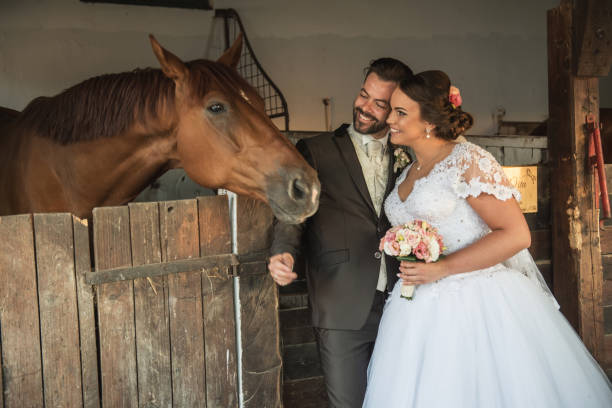 istock Beautiful young couple with horses 813698286