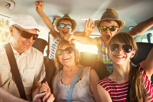 Grandparents having fun on road trip with grandchildren Senior couple aged 70 and their three grandchildren aged 11 and 7 are having fun during road trip. 

 car interior photos stock pictures, royalty-free photos & images