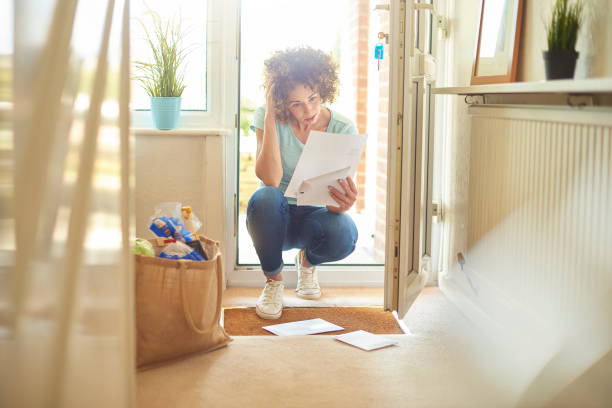didn't get the job a woman returns home from the shops and finds some letters on the mat . She bends down to open them and runs her hand through her hair in despair key doormat stock pictures, royalty-free photos & images