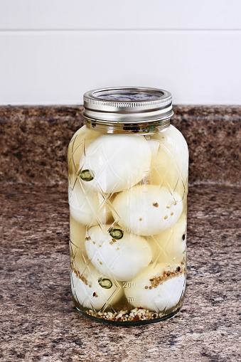 Mason jar filled with old fashioned  pickled eggs preserved at home.