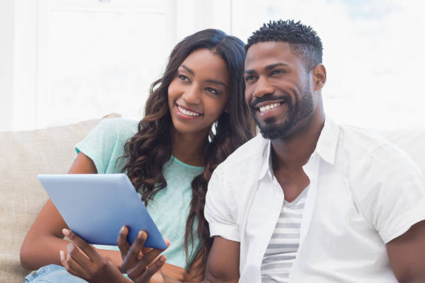 istock Happy couple using tablet together on the couch 813716934