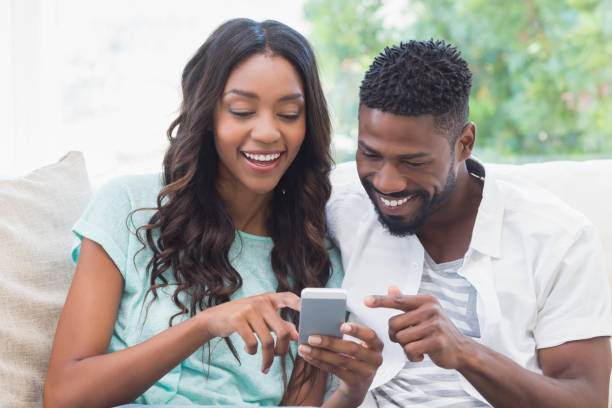 istock Happy couple on the couch using phone 813717194