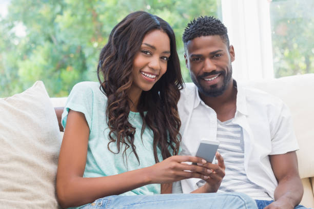 istock Happy couple on the couch using phone 813717326