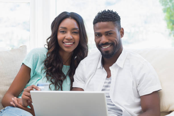 istock Happy couple on the couch using laptop 813717612