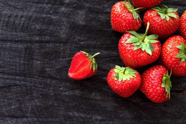 istock Red fresh strawberries on black rustic wood background 813730232