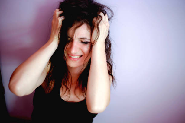 istock A very upset and lonely woman sitting down crying against a wall 813736104