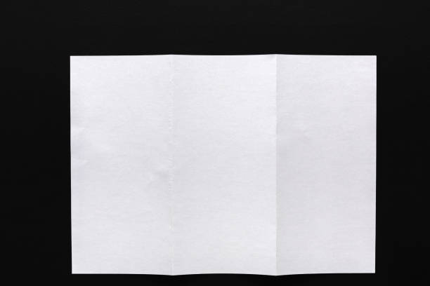 istock White folded sheet of paper on black background 813742998