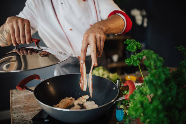 istock The cook adds bacon strips in the pan 813746634