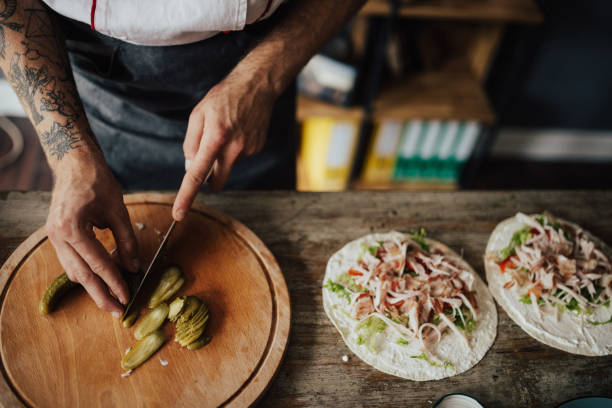 istock Chef cuts picles in thin slices for wrap sandwich 813765250