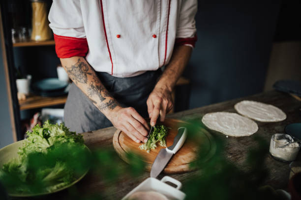 istock Chef cuts salad with knife on wooden board 813765870
