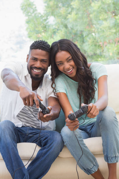 istock Happy couple on the couch playing video games 813766636