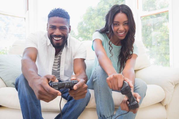 istock Happy couple on the couch playing video games 813768928