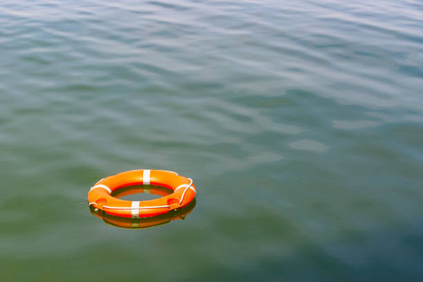 une bouée de sauvetage flottant sur l’eau - help mot anglais photos et images de collection