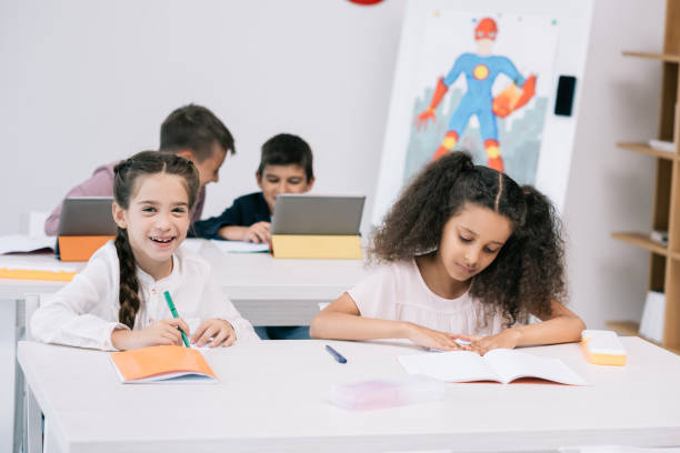 istock Multiethnic group of pupils writing in exercise books and using digital tablets during lesson 813775236