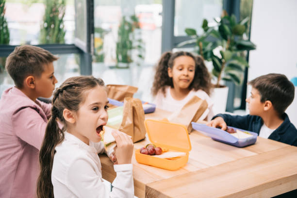 istock Multiethnic group of schoolkids eating lunch while sitting together at table 813783038
