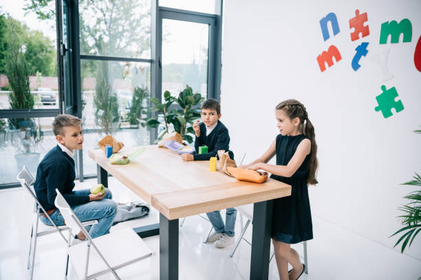 istock Cute little classmates eating lunch at break in school 813785576