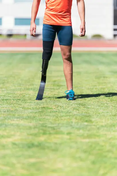 Close up disabled man athlete with leg prosthesis. Paralympic Sport Concept.