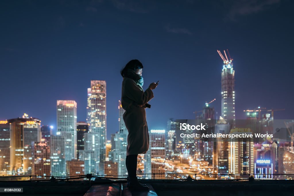 Asian Woman Using Mobile Phone In Downtown District City Stock Photo