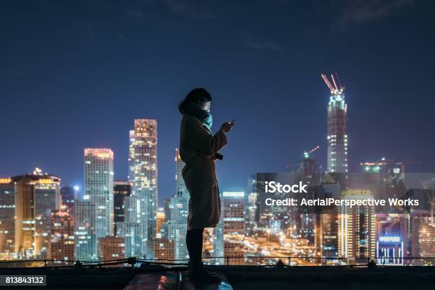 Asian Woman Using Mobile Phone In Downtown District Stock Photo - Download Image Now