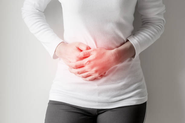 istock Woman stomachache on gray wall background. 813843398