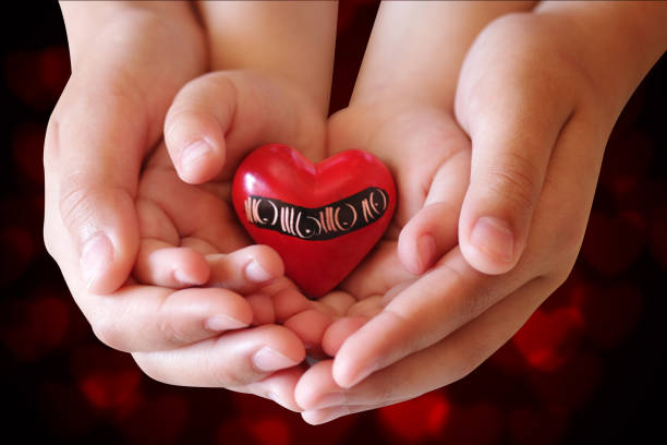istock Hands holding a red heart on a black background 813843540