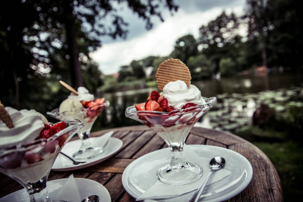 erdbeer eisbecher garniert mit schlagsahne - fruchtgarnierung stock-fotos und bilder